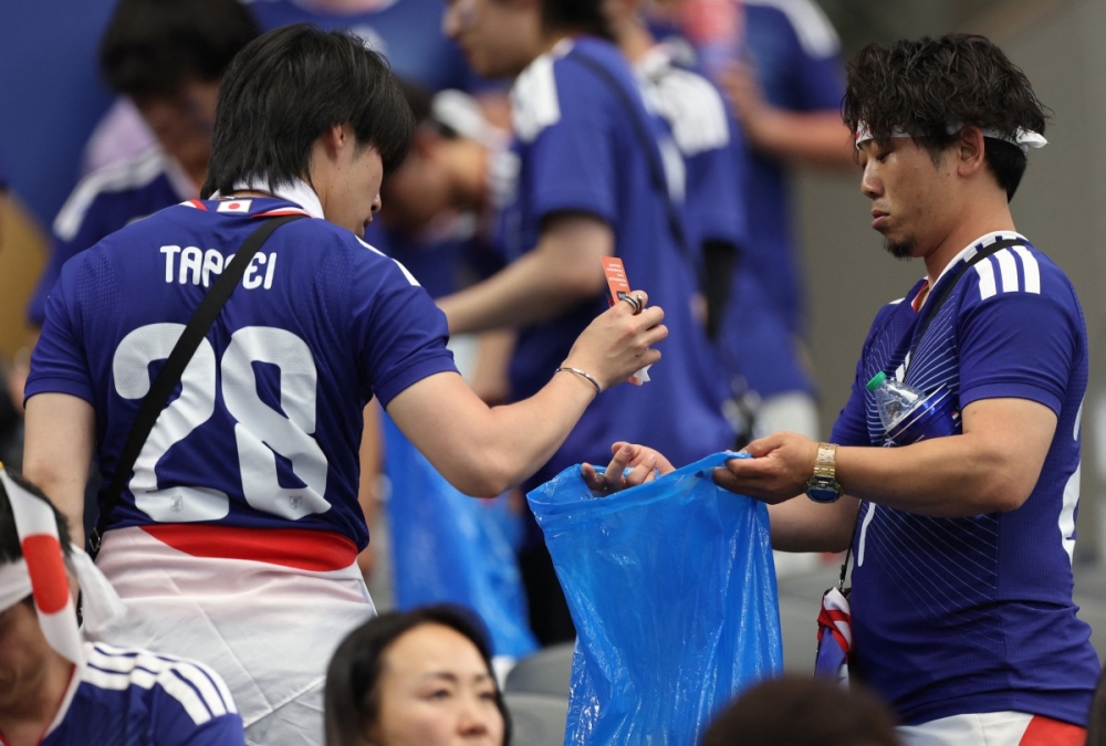 Japanese football fans clean up rubbish in the stands after their country’s 2-2 World Cup 2026 draw with the Netherlands on June 14, 2026. — AFP pic