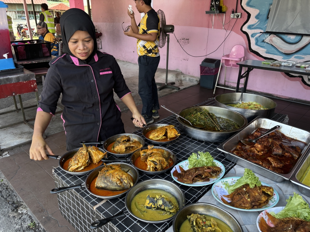 3 Generation Restaurant owner Nur Akma Mohamad Nassier arranges dishes at her restaurant in Tanjung Rambutan, Ipoh. The eatery serves a basic RM3 lunch comprising rice, a piece of fried or soy sauce chicken, vegetables and curry. — Picture by John Bunyan