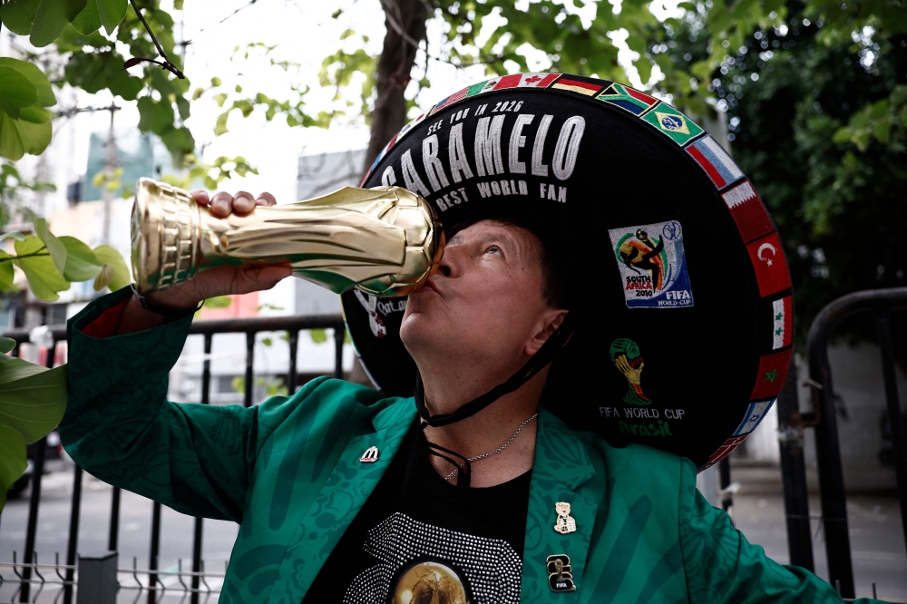 A Mexican fan kisses a World Cup replica ahead of the arrival of Mexico's players at the Hilton Guadalajara Midtown Hotel during the 2026 World Cup football tournament in Guadalajara, Mexico on June 16, 2026. Hotel districts in major World Cup host cities are seeing uneven demand as early pricing bets by the hospitality sector fail to fully materialise. — AFP pic