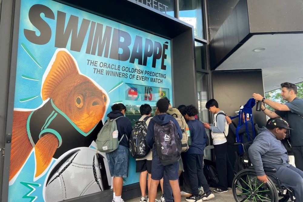 A crowd of soccer fans and children gather to watch Swimbappe, an oranda goldfish that makes daily World Cup match predictions, in Toronto, Ontario, Canada, June 19, 2026. — Reuters pic