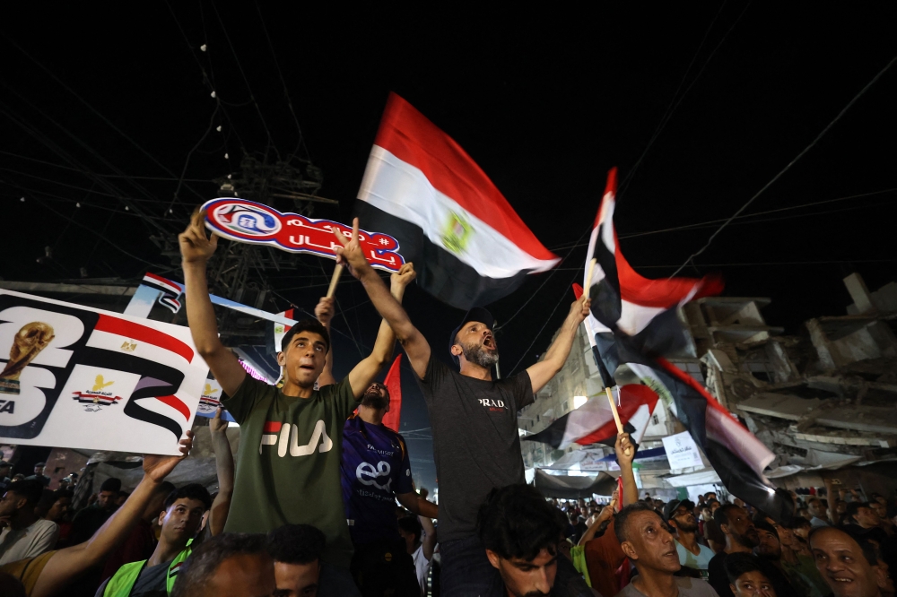 Palestinian fans in Gaza’s Nuseirat camp watch Belgium vs Egypt on a giant screen, cheering Salah despite ruins and blackouts, June 15, 2026. — AFP pic