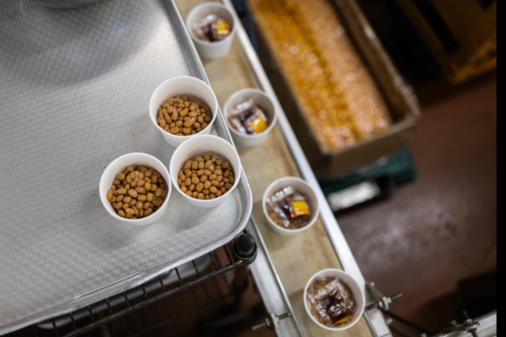 Cups of ‘natto’ awaiting to be sealed at the Kamakurayama Natto production facility in Kamakura. — AFP pic