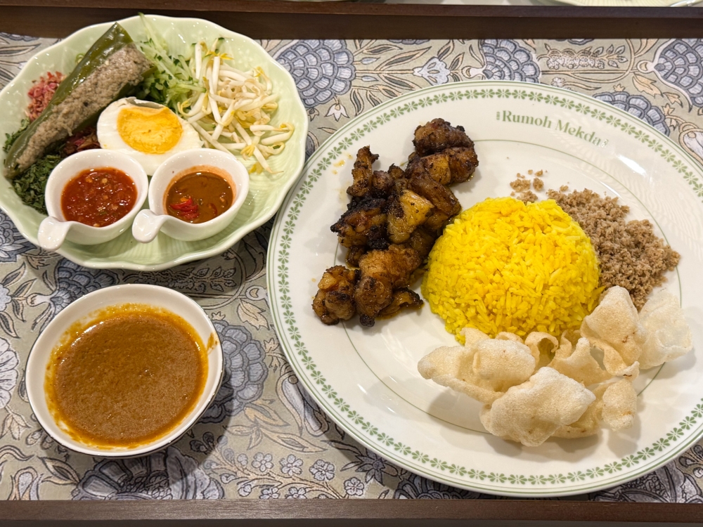 Nasi Kerabu Lemak Bakar has lighter, more refined flavours: mix the vegetables, ‘kerisik ikan’, ‘budu’, ‘sambal belacan’ and ‘gulai tumis’ together with the rice and your choice of protein. — Picture by Lee Khang Yi