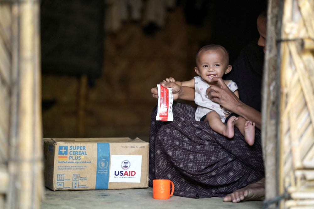A Rohingya woman feeds nutrition supplements that have been provided by USAID, to a child at a refugee camp in Cox’s Bazar, Bangladesh, February 11, 2025. — Reuters pic