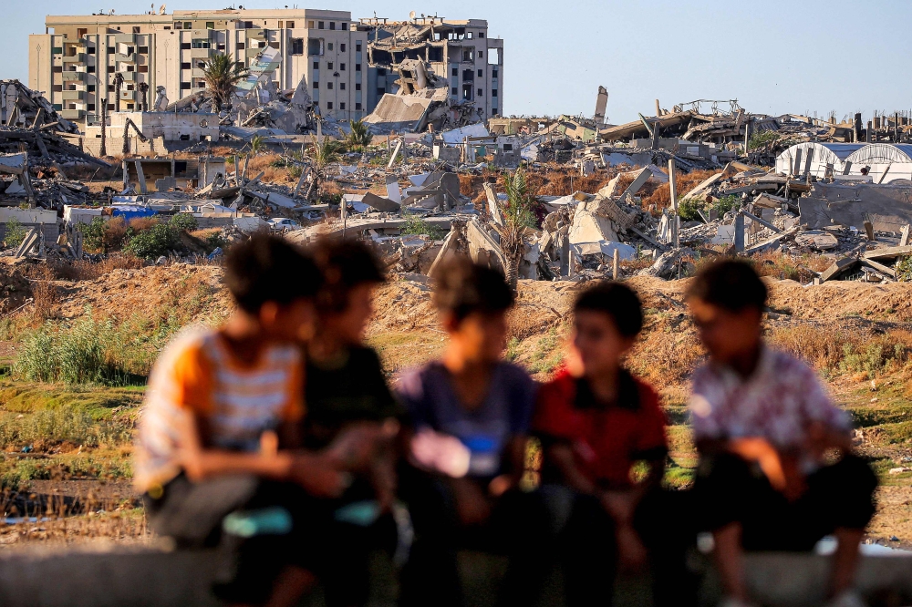 Children sit together near destroyed and heavily damaged buildings at the Nuseirat camp for Palestinian refugees in the central Gaza Strip on June 19, 2026. — AFP pic