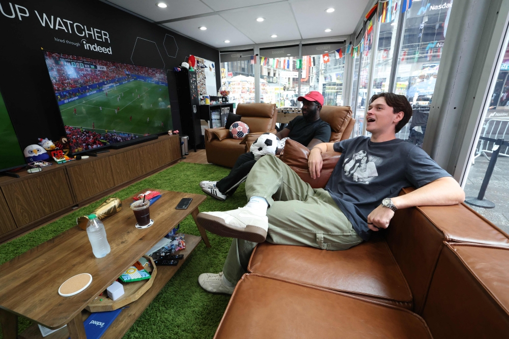 These two fans quit real life to watch the entire World Cup from a glass cube in New York’s Times Square for US$50,000