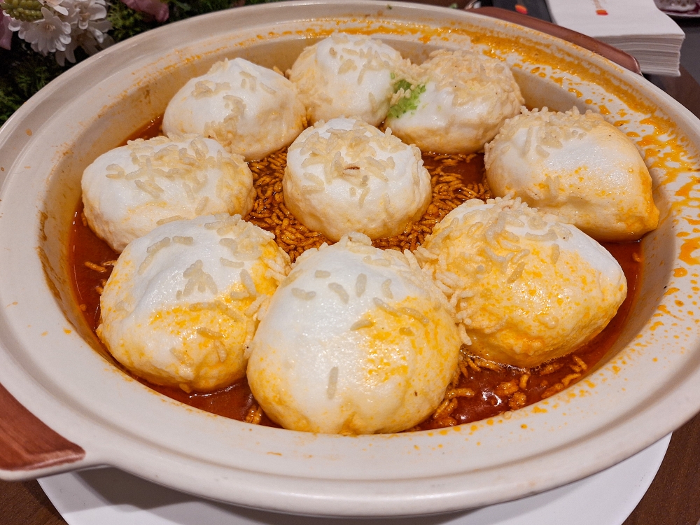 Handmade scallop paste balls, each as large as a bowl and denser than its fluffy looks, are seen together with crispy rice in a rich seafood soup. — Picture by Ida Lim
