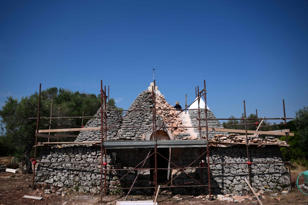 A ‘trulli’ restorer works on the restoration of an iconic dry-stone dwelling with conical roofs called ‘trullo’, in the Itria Valley near Ostuni, in the southern region of Puglia, on June 24, 2026. — AFP pic
