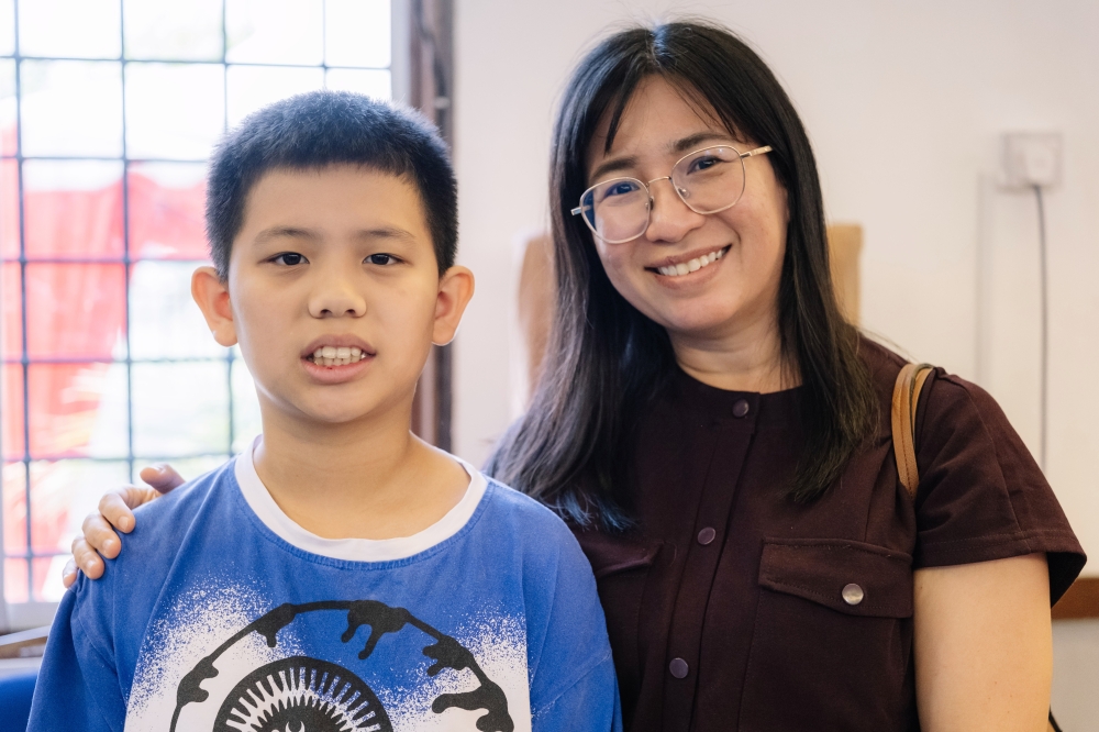 Tan Pei Syien (right) with her son at the Universiti Malaya’s community health and dengue drive in Kepong. — Bernama pic