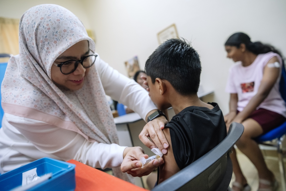 Children aged seven to 12 receive dengue vaccination during Universiti Malaya’s community health drive in Kepong. — Bernama pic