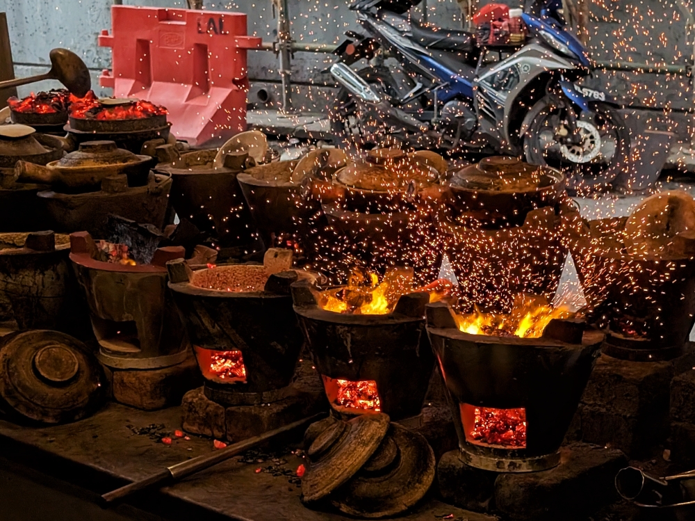 Dinner and a show: part of the experience of a meal at Heun Kee, and now Yan Kee, is watching the embers glow and flames rage as each order of claypot chicken rice is fired. — Picture by Ethan Lau