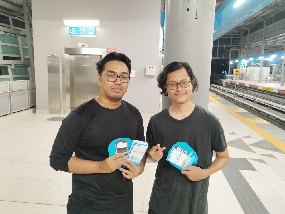 Classmates, Muhammad Irfan Waiz (left) and Muhammad Muqriy Muhammad Wildan, waiting for their first LRT3 train to arrive at the station. — Picture by Muhammad Yusry