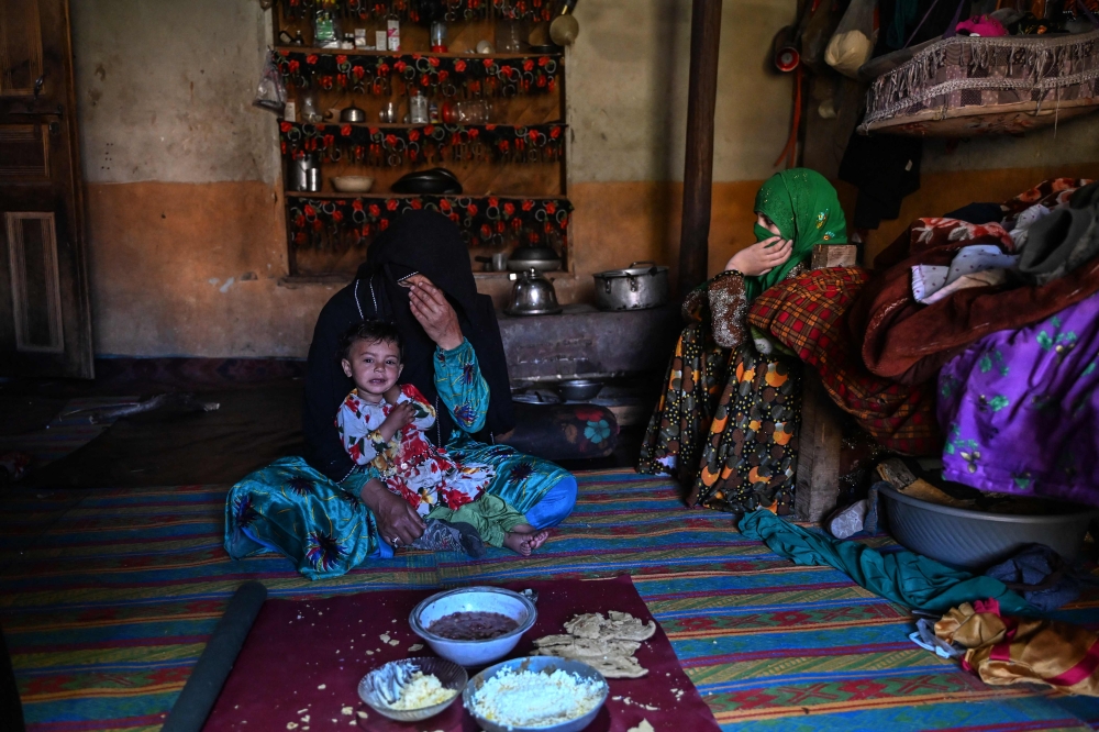 This photograph taken on June 8, 2026 shows Afghan woman farmer Habiba (left) sitting with her daughter Zuheida (right) and granddaughter Saeeda during breakfast at their residence in the Eshtiwi village of Afghanistan’s Parun district. — AFP pic 