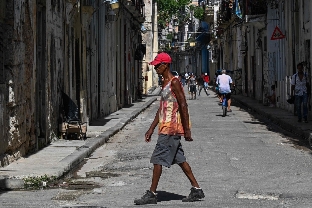 A man wearing a T-shirt featuring the US flag walks down a street in Havana on 30 June 2026. — AFP pic