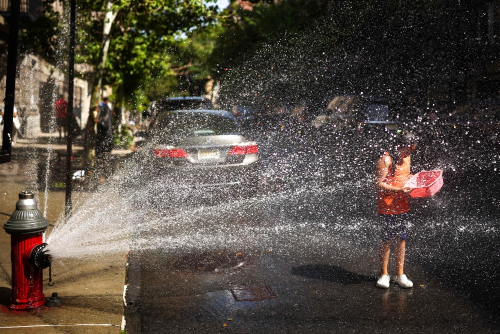 New Yorkers crack hydrants to cool off as 43°C heat index melts city streets