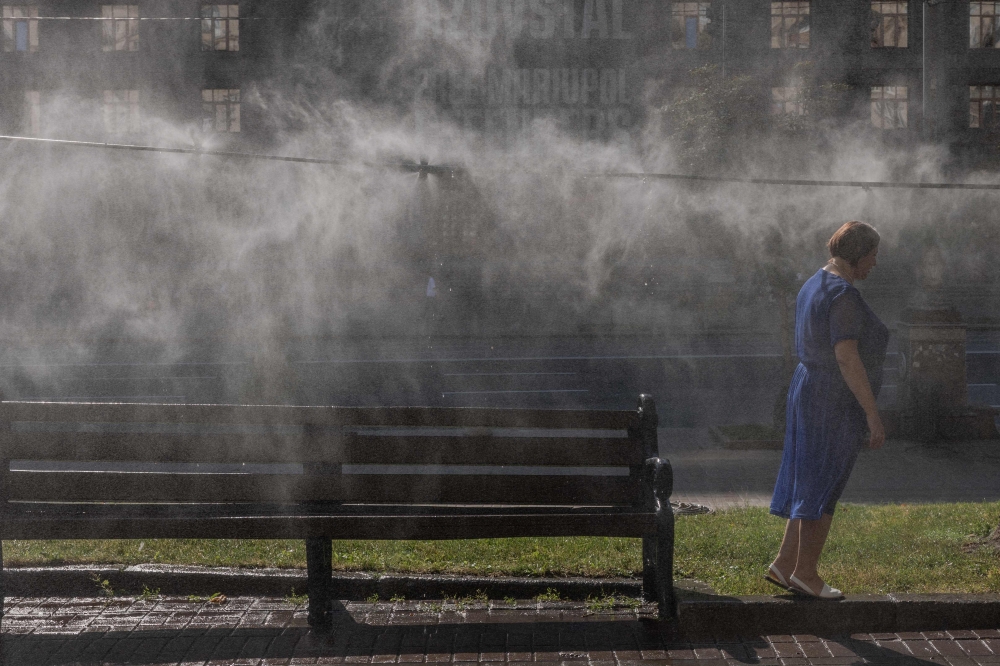 A woman cools off under cooling misters as the European heatwave shifts east to the Balkans and Ukraine, in Kyiv on June 30, 2026, amid the Russian invasion of Ukraine. — AFP pic 