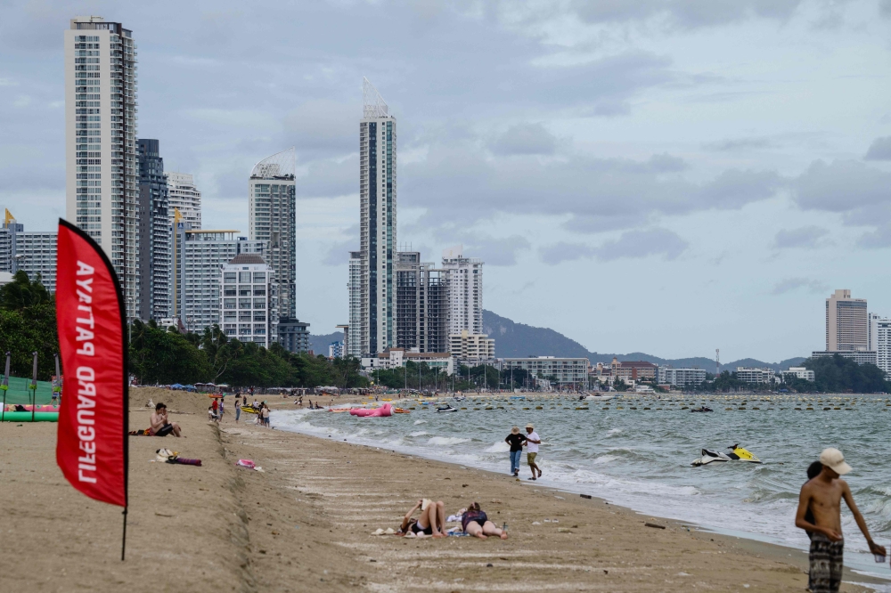 Beachgoers relax and walk along the shoreline on Pattaya Beach, in Pattaya on June 29, 2026. — AFP pic