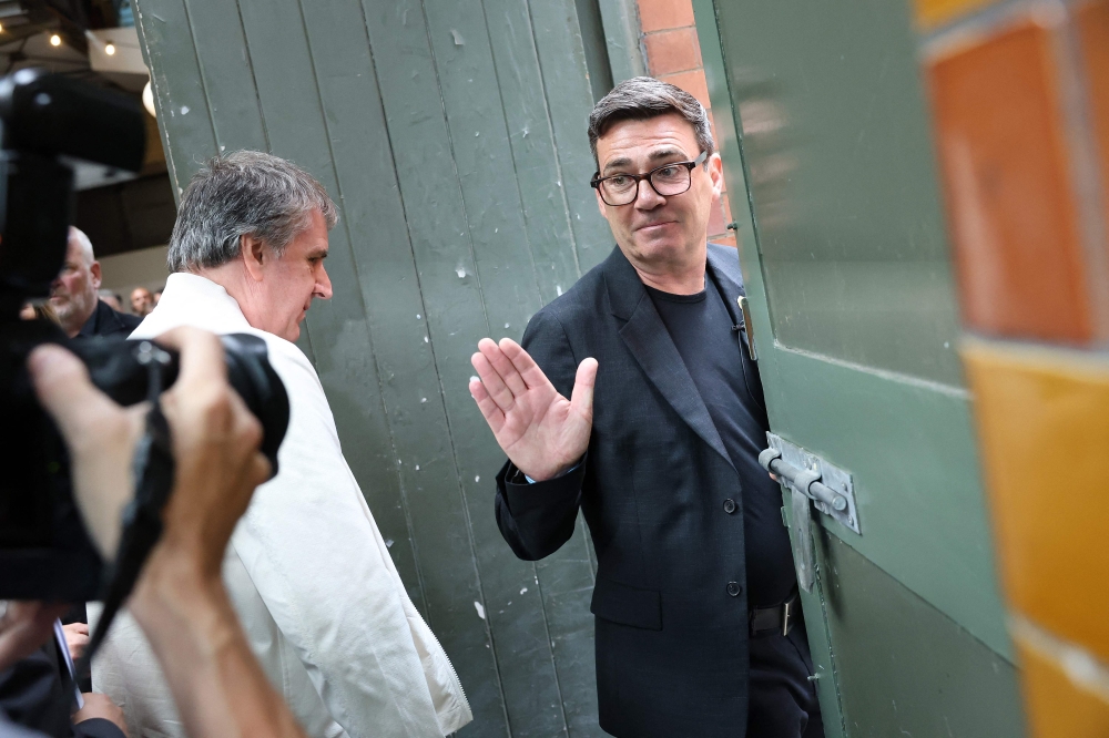 Labour MP and challenger for Leader of the Labour party, Andy Burnham, (right) waves as he leaves with Mayor of the Liverpool City Region Steve Rotherham, after delivering a speech in Manchester June 29, 2026. — AFP pic