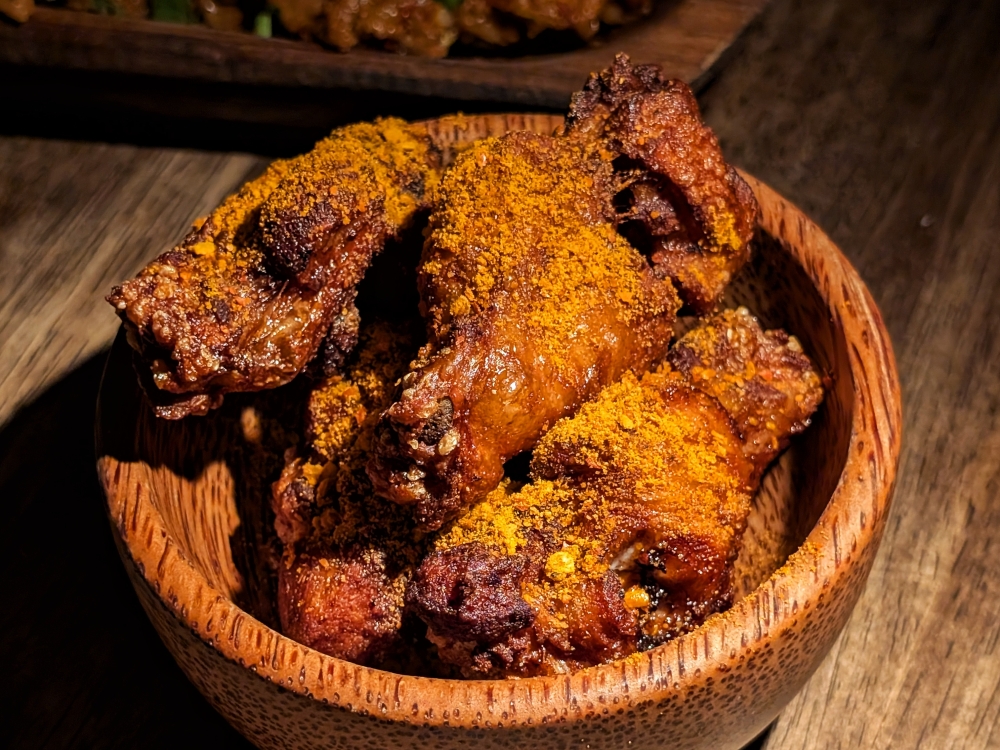 The fried drummettes are covered with a mystery powder that keeps you going back in for more . 