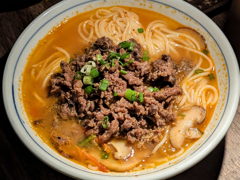 Red sour soup, a classic Guizhou dish, served with rice noodles and topped with beef.