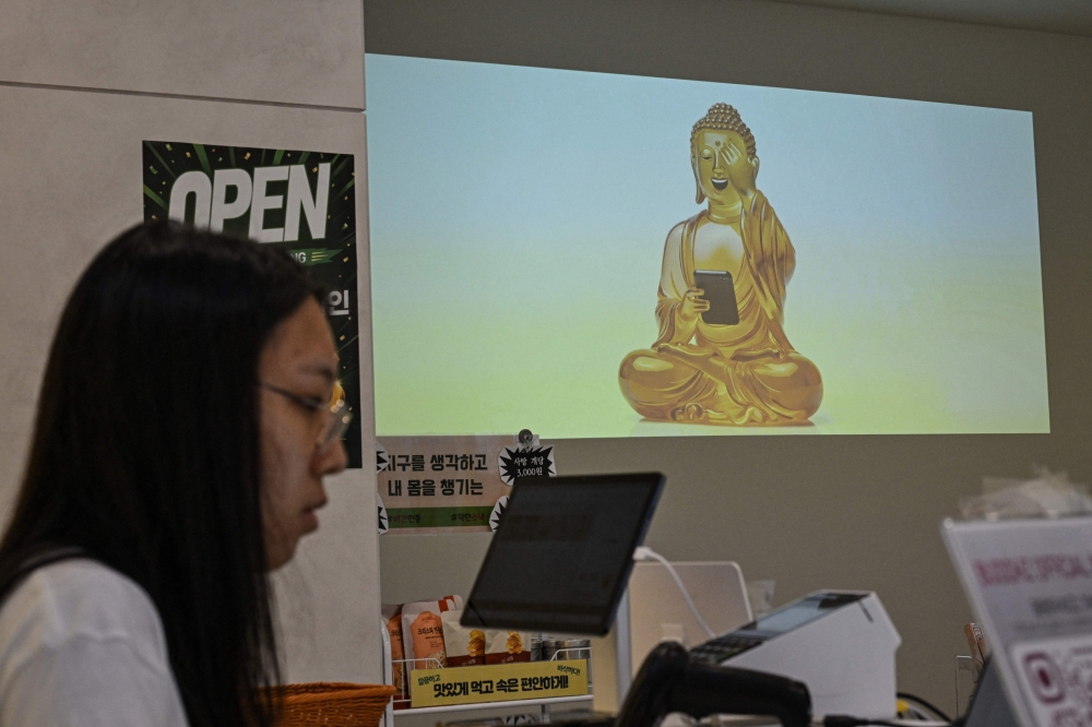 A projection of Buddha is displayed using a smartphone at a souvenir store in Seoul on July 6, 2026. — AFP pic