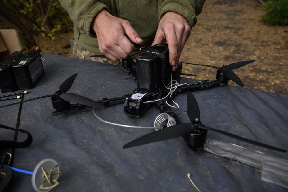 A Ukrainian soldier of the Black Wing unit, 116th Mechanized Brigade, tests an FPV drone at a workshop facility at an undisclosed location near the front line in the Kharkiv region of eastern Ukraine on October 8, 2025. — AFP pic