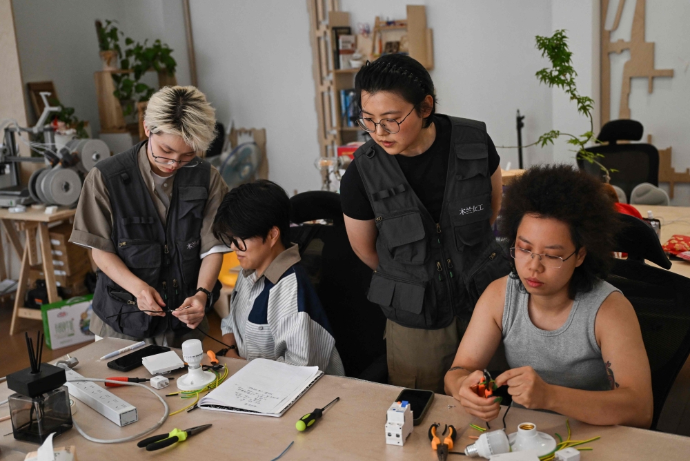 Wu Shuang (centre) and Wang Risun (left) give an electricity course to a group of women at the Mulan Build workshop in Hangzhou, in eastern China’s Zhejiang province on June 28, 2026. — AFP pic
