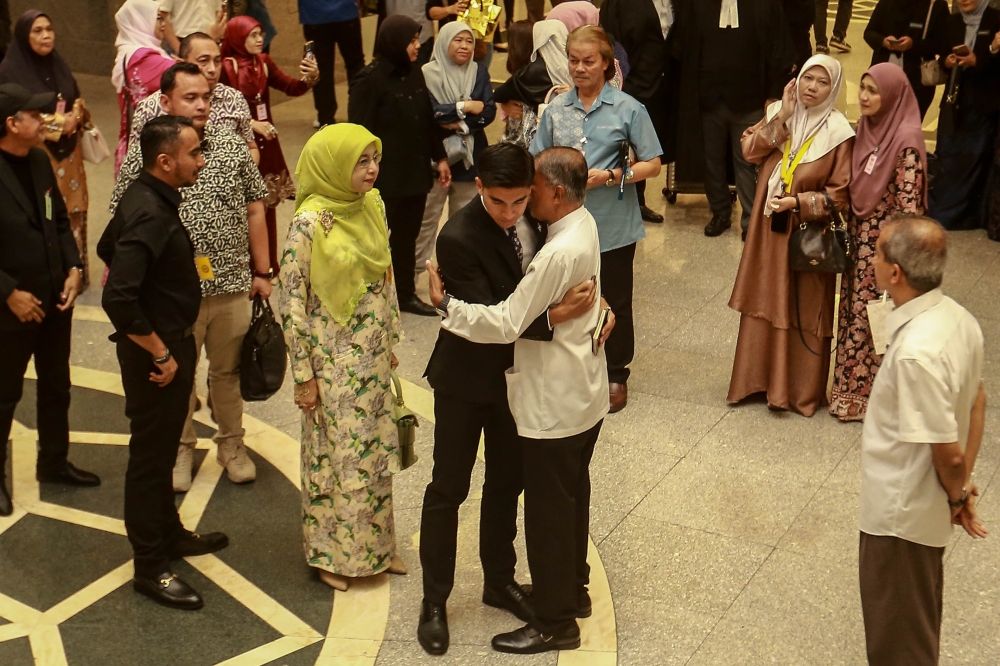 Muar MP Syed Saddiq Syed Abdul Rahman embracing his family (centre) after hearing the Federal Court verdict on his corruption case at the Palace of Justice in Putrajaya on July 13, 2026. — Picture by Sayuti Zainudin