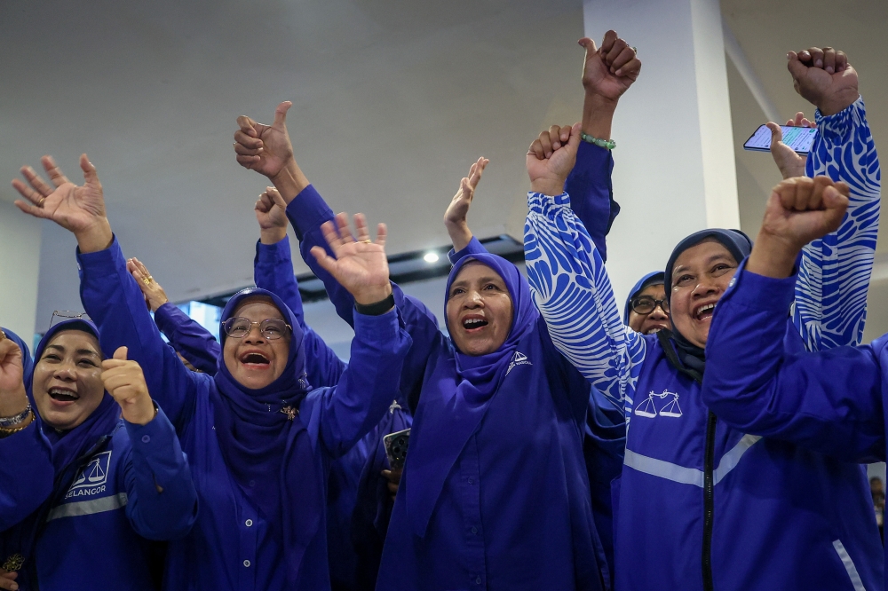 Party members celebrate after viewing unofficial results showing Barisan Nasional leading in several seats during the Johor state election at the Johor Umno Liaison Body headquarters on July 11. — Bernama pic