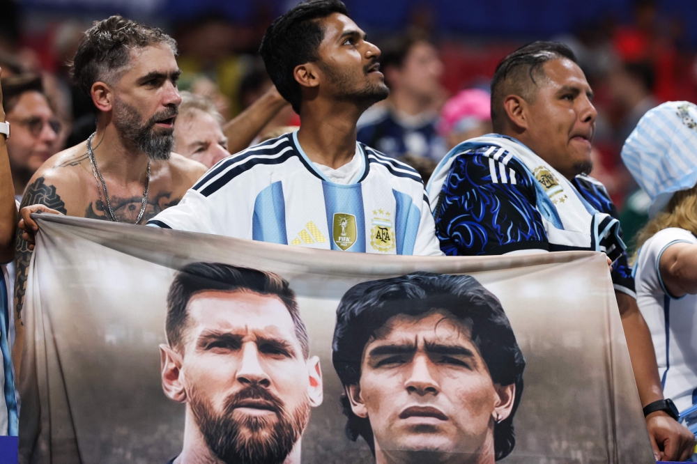 An Argentina fan holds a flag depicting Argentina forward Lionel Messi (left) and Argentine football legend Diego Maradona (right) after the FIFA World Cup 2026 semi-final match against England at Atlanta Stadium in Atlanta on July 15, 2026. — AFP pic