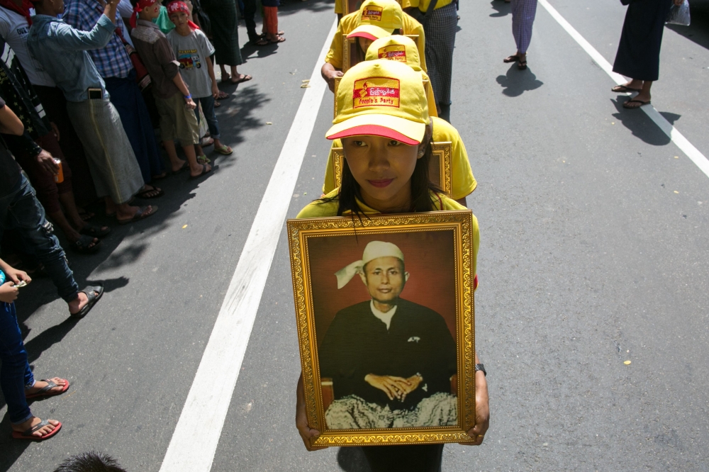 Girls parade with a portrait of General Aung San during the Martyrs’ Day ceremony in Yangon on July 19, 2019. — AFP pic