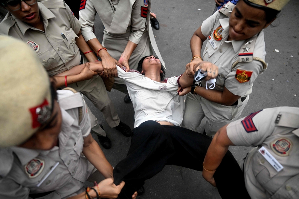 Police detain a Cockroach Janta Party supporter during a protest demanding the resignation of India’s education minister over alleged examination irregularities on July 20, 2026. — AFP pic