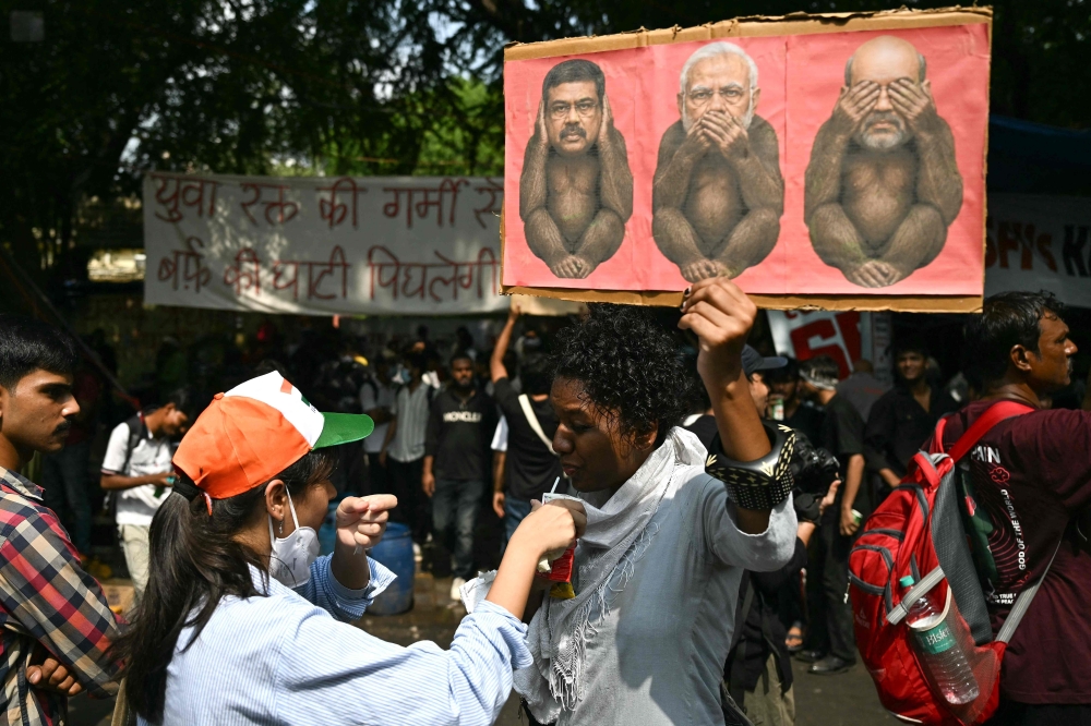 A Cockroach Janta Party supporter drinks ORS during a protest at Jantar Mantar in New Delhi on July 23, 2026. — AFP pic