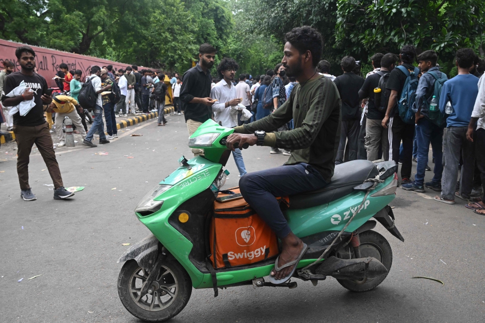A food delivery rider arrives at Jantar Mantar in New Delhi. — AFP pic