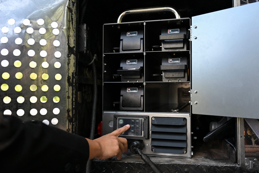 A person checks the batteries of an electric battery powered food cart in Flushing Meadows-Corona Park on July 23, 2026 in New York City. — AFP pic