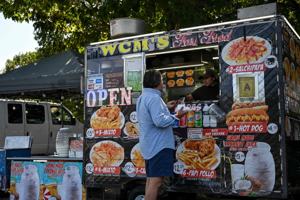 A person purchases a hot dog from an electric battery powered food cart in Flushing Meadows-Corona Park on July 23, 2026 in New York City. — AFP pic