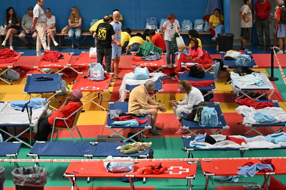 Evacuees rest in a sports hall in Villaviciosa de Odon, 20 kilometres west of Madrid, on July 25, 2026 amid wildfires that have burned up to 25,000 hectares. — AFP pic