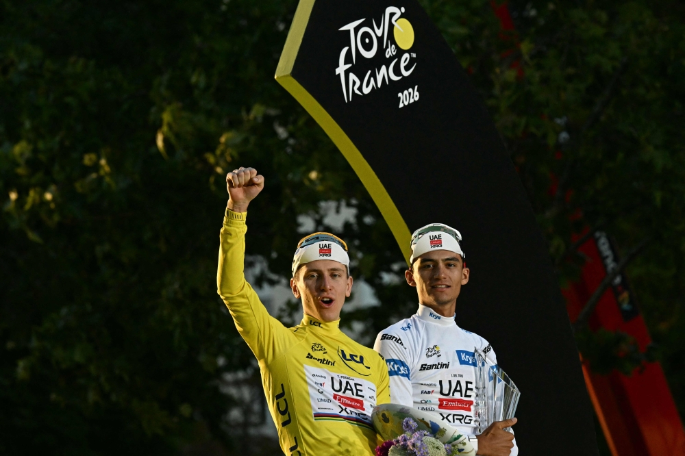 Tour de France overall winner Tadej Pogacar of UAE Team Emirates - XRG celebrates on the podium with third-placed teammate Isaac Del Toro after the 21st stage in Paris on July 26, 2026. — AFP pic