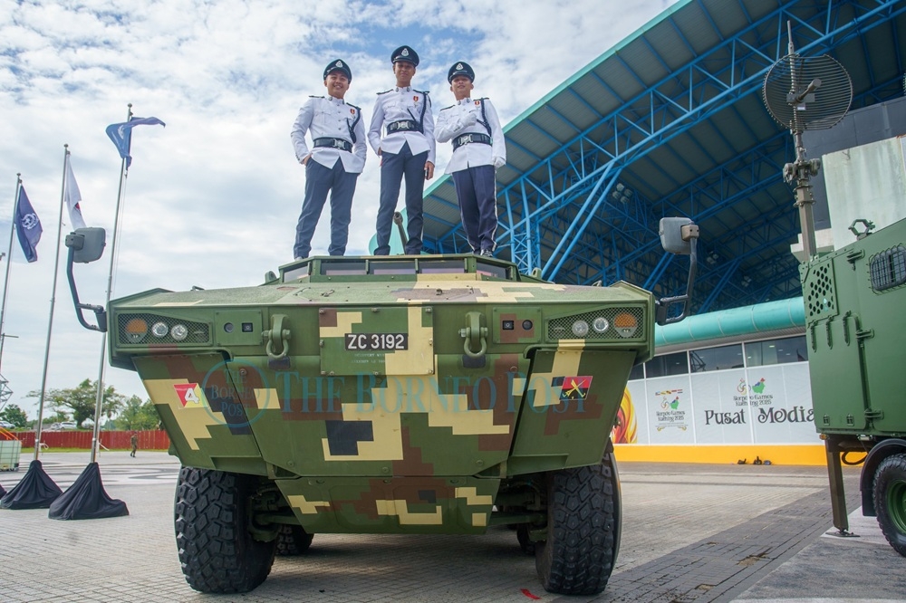 Three personnel pose on an armoured vehicle displayed during the 2026 Sarawak-level Warriors’ Day celebration. — Mohd Faisal Ahmad/The Borneo Post pic