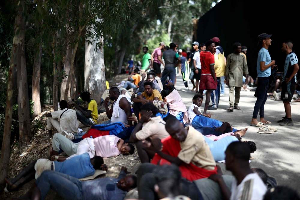Migrants remain outside the CETI short-stay migrant centre in the Spanish North African enclave of Ceuta August 1, 2026. — AFP pic