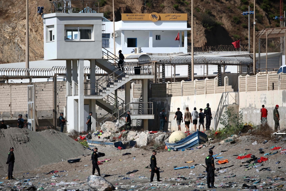 Some migrants arrive at the border post with the intention of crossing back into Morocco as members of the Spanish armed forces keep watch over the area in the Spanish enclave of Ceuta August 2, 2026. — AFP pic