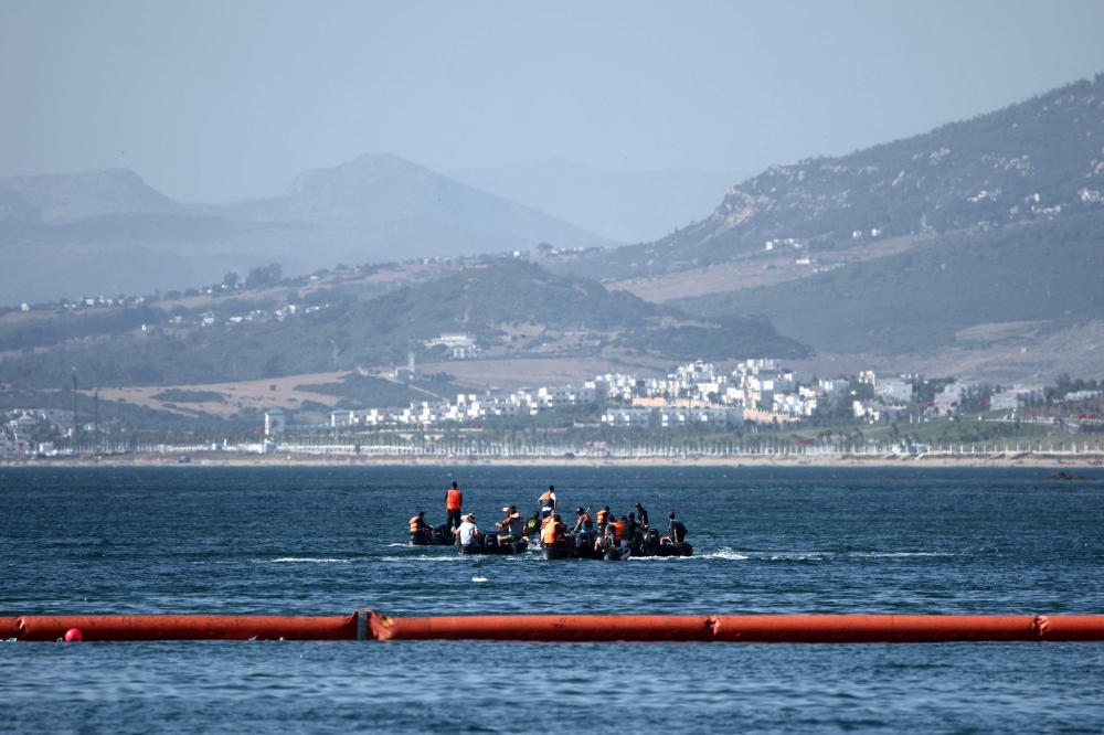 People aboard inflatable boats navigate on the Moroccan side of the new floating barrier deployed by Spain to reinforce security near the border post of the Spanish enclave of Ceuta on August 2, 2026. — AFP pic