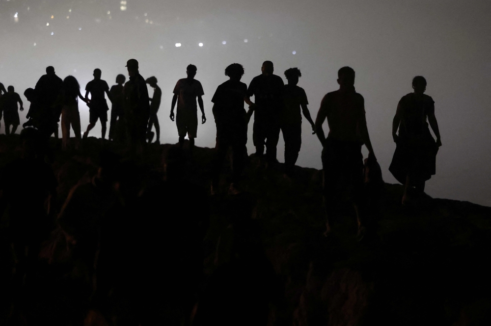 Migrants walk towards the Fnideq region in northern Morocco after leaving Spain’s North African enclave of Ceuta following an attempted crossing at the Bab Sebta border crossing on the outskirts of Fnideq on August 1, 2026. — AFP pic