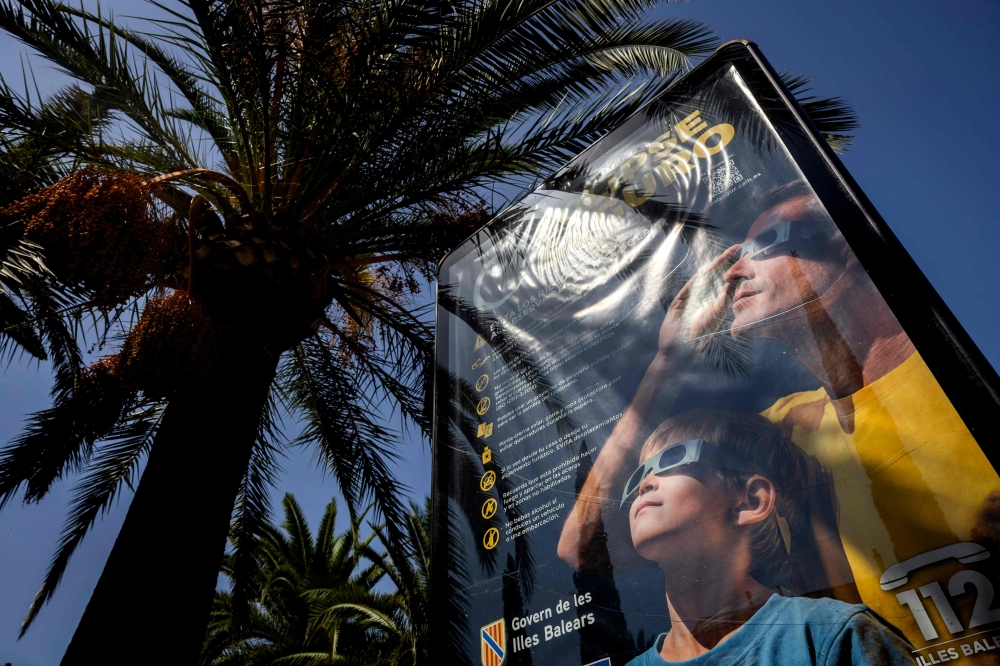 An information panel displays measures on how to safely view an upcoming solar eclipse on a street in Palma de Mallorca on July 31, 2026. — AFP pic