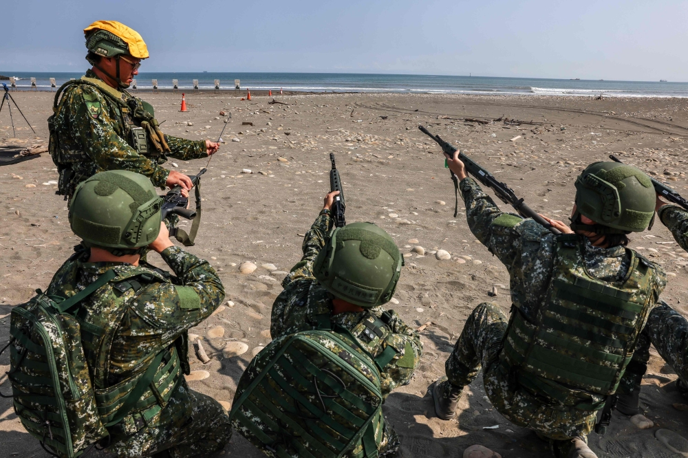 Taiwanese soldiers clean the barrels of their rifles after a live-fire exercise on Zhongfu Beach as part of annual Han Kuang military exercise in New Taipei City on August 5. — AFP pic
