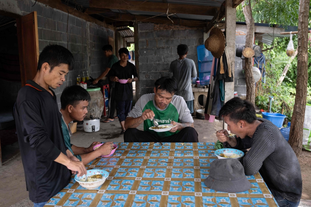 Karen refugees from the refugee camps along the Thai-Myanmar border eat lunch while on break at a rice farm in Nakhon Sawan province on August 5, 2026. — AFP pic