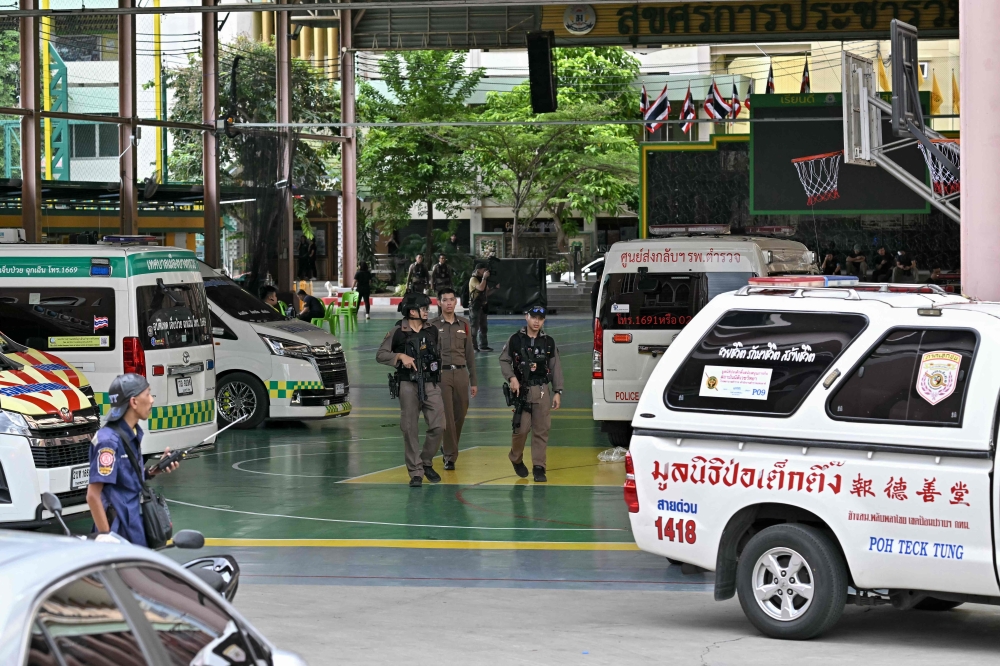 Armed police search Debsirin Nonthaburi School after a teen shooter killed eight people, including his grandparents, three teachers and three students, in one of Thailand’s deadliest school shootings in recent years. — AFP pic