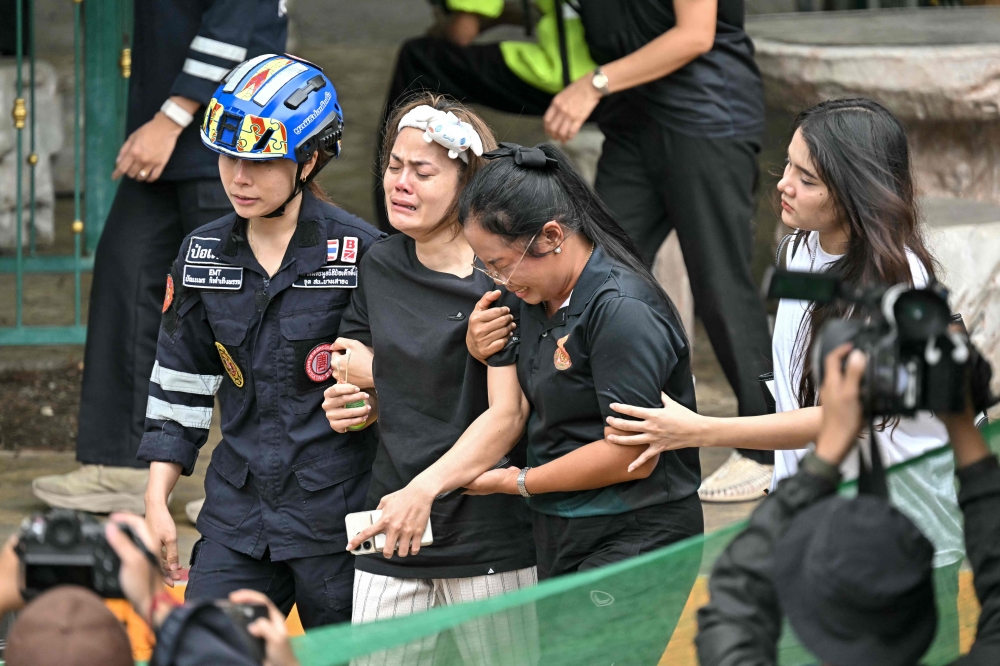 Relatives of a teacher who was killed at Debsirin Nonthaburi School are led to an ambulance in Bang Kruai district, Nonthaburi province north of Bangkok, on August 7, 2026. — AFP pic