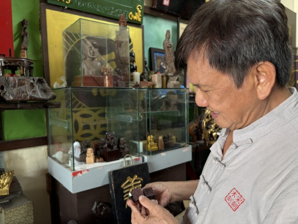 Lee Chee Cheng showing the traditional Chinese name stamps that he also makes. — Picture by Opalyn Mok