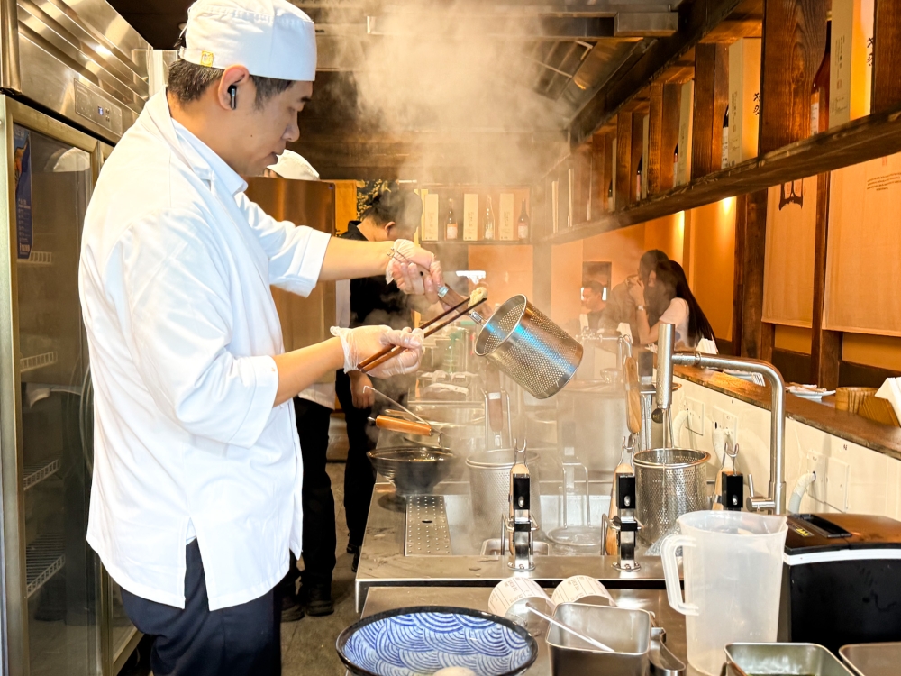 Chef Moritani cooks the 'ramen' bowl by bowl behind the counter. — Picture by Lee Khang Yi